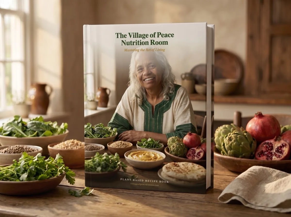 The Village of Peace Nutrition Room recipe book on a kitchen table with plant-based dishes