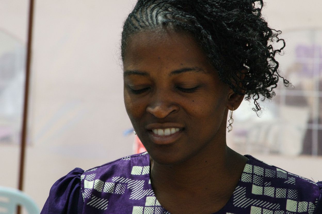 Woman with cornrow braids in a purple top — community member portrait