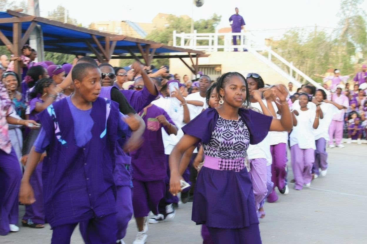 Youth performing a synchronised dance in purple and white outfits