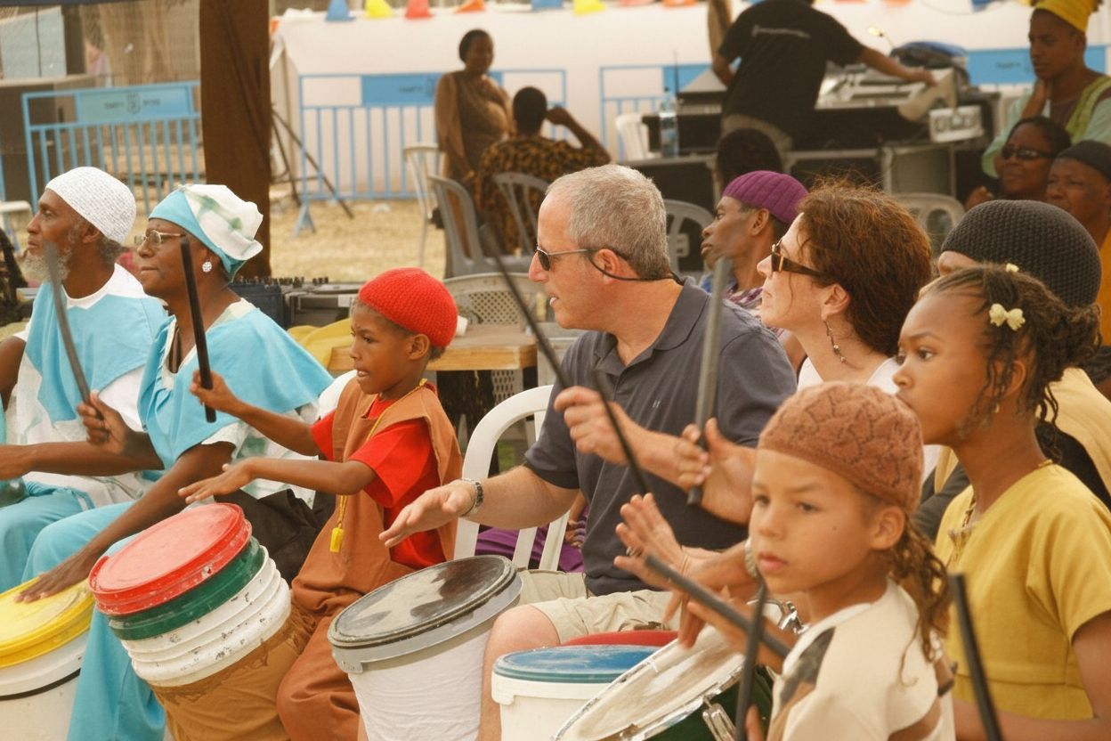Children and visitors joining a drum circle together in the village